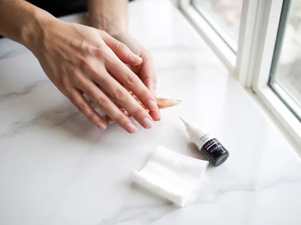 lifted acrylic nail moisture hazard green nail risk home repair tools alcohol wipe nail glue close up